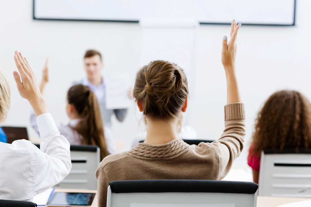 Young teacher in classroom standing in front of class